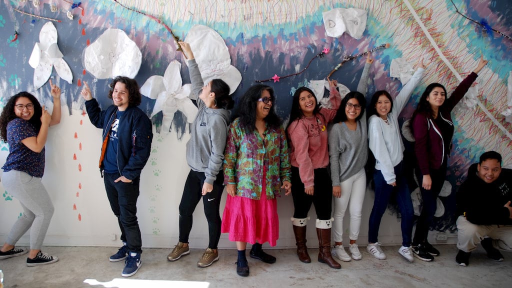 Consuelo Jimenez Underwood with children in front of mural, Craft in America